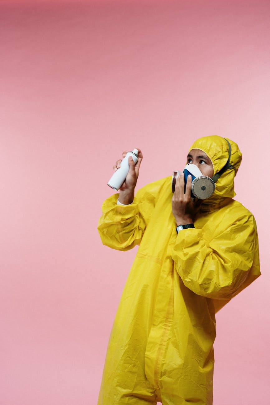 man in yellow coveralls holding spray bottle