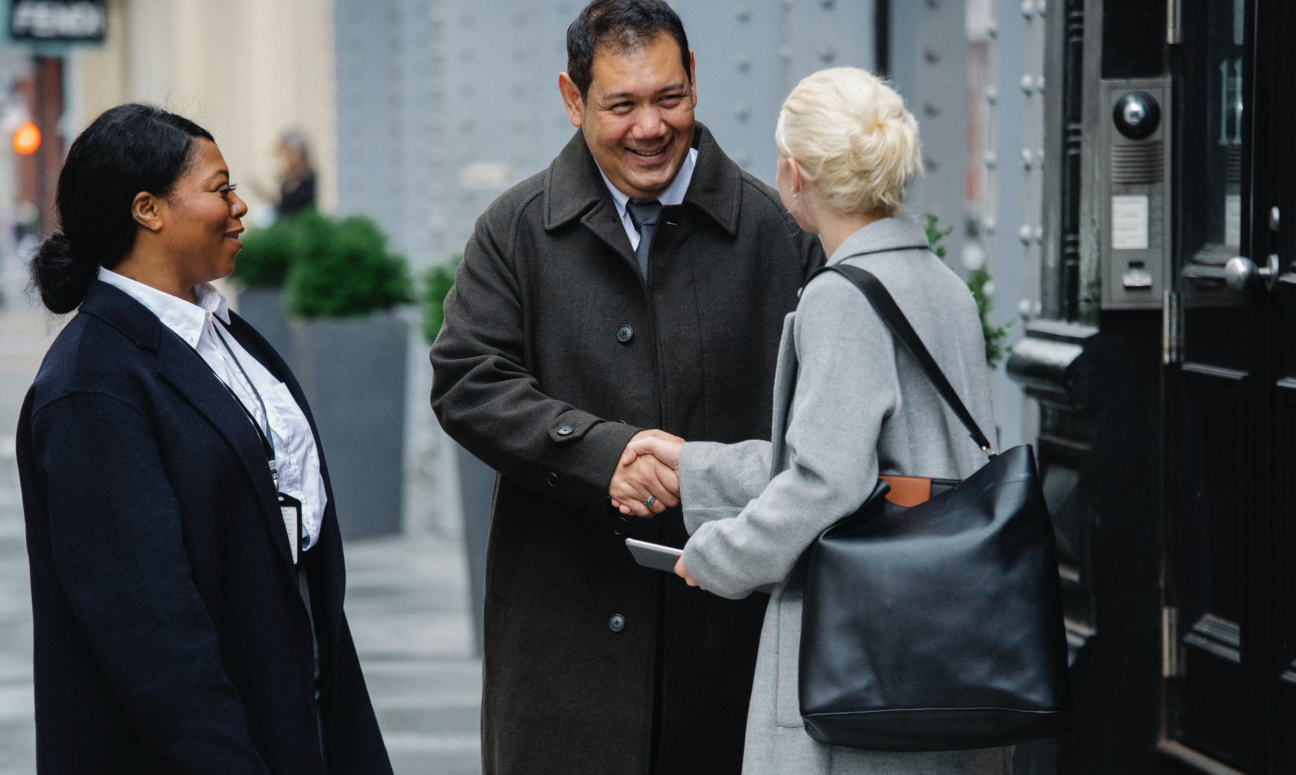 positive ethnic colleagues greeting anonymous female partner on street